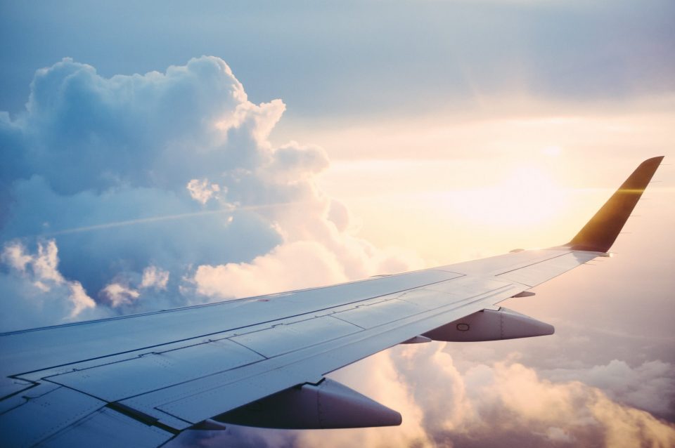 Flygplansvinge med moln bakom
